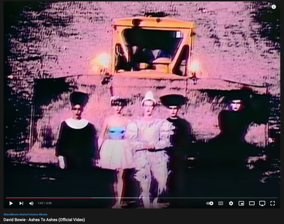 Still from Bowie's Ashes To Ashes 1980 showing a bulldozer behind a group of people walking