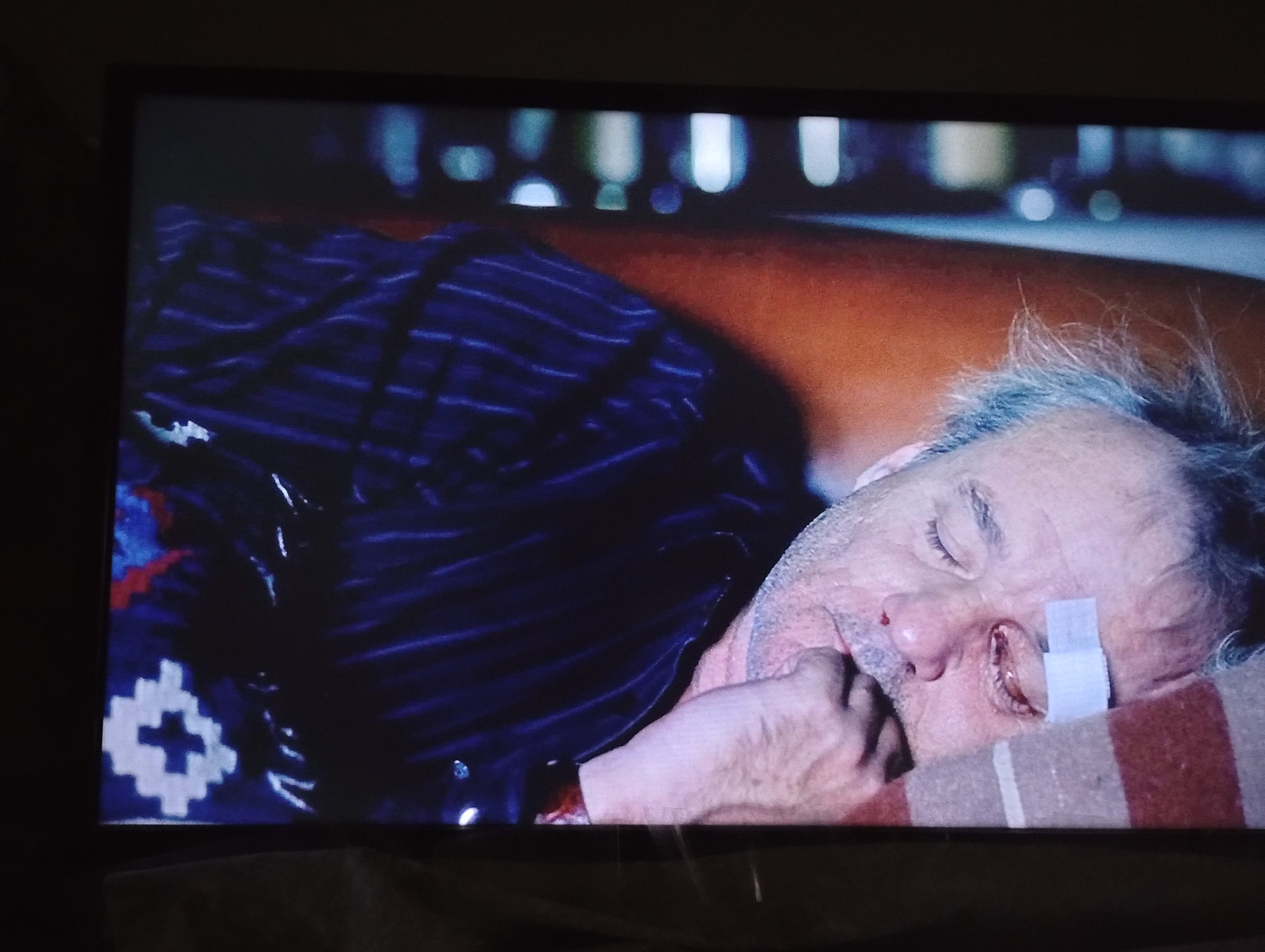 still from Jim Jarmusch movie Broken Flowers showing Don Johnston character clutching a pillow with a stair step design